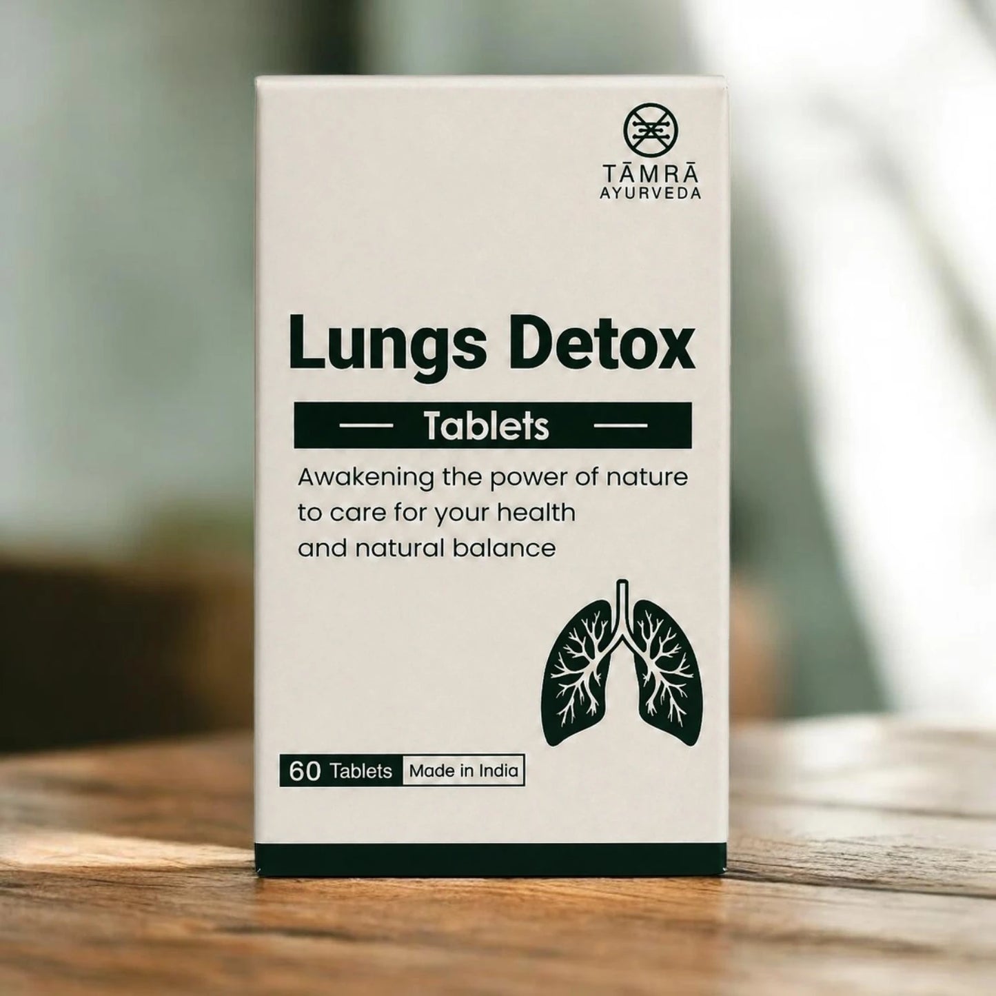 Box of Támra Ayurveda Lungs Detox Tablets on a wooden surface with a blurred background