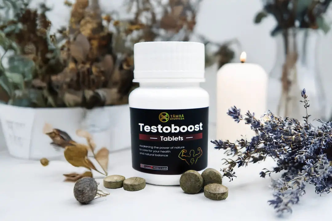 Tamra Testoboost supplement bottle with tablets on a decorative surface with candles and plants.