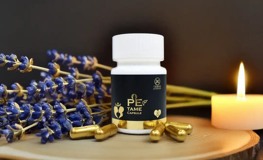 Supplement bottle labeled 'PE TAME' by Tamra Ayurveda with capsules and lavender on a wooden surface.