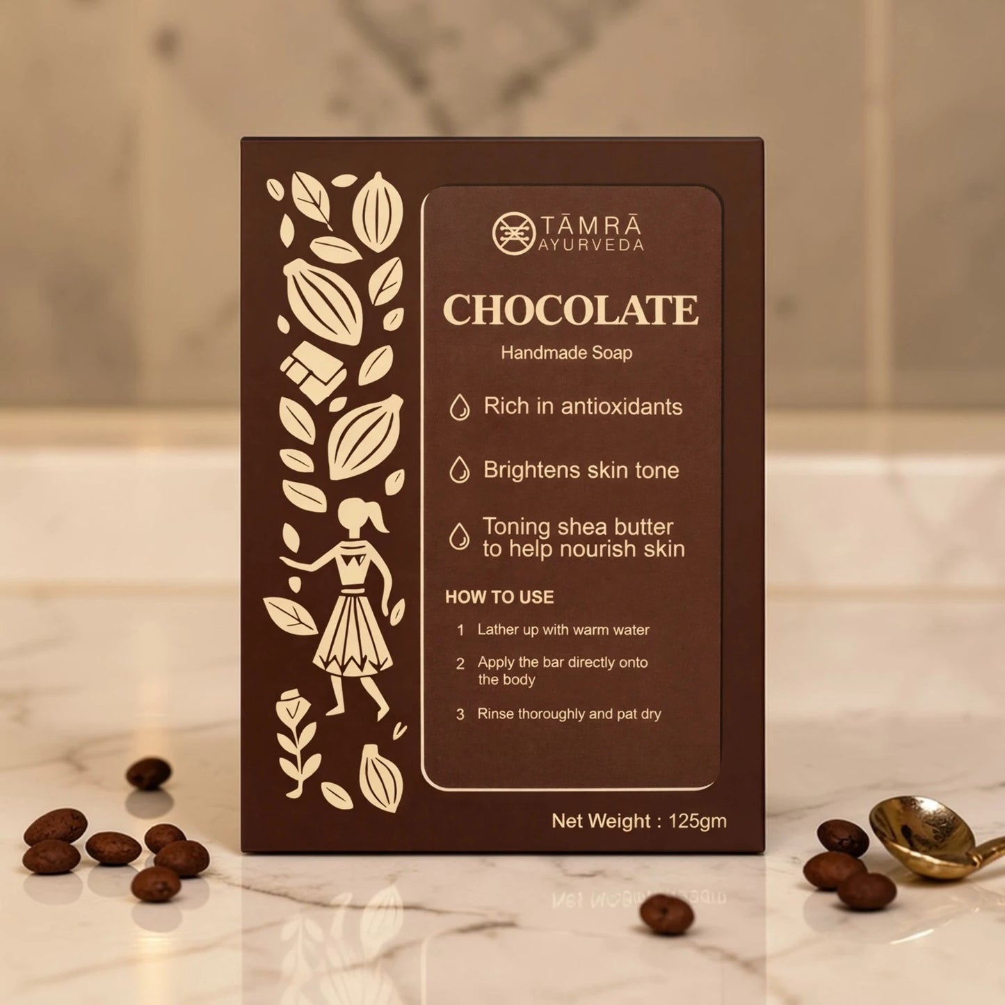 Tamra Ayurveda chocolate handmade soap packaging on a marble surface with cocoa beans.
