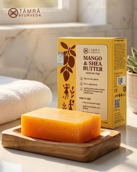 Mango and Shea Butter soap bar on a wooden stand with packaging in the background, featuring Tamra Ayurveda branding.