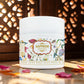 White jar with floral label on a wooden surface with saffron strands and petals.