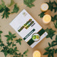 Box of 'Tamra Garcinia Cambogia Vrikshamla' capsules surrounded by green leaves and candles on a beige surface