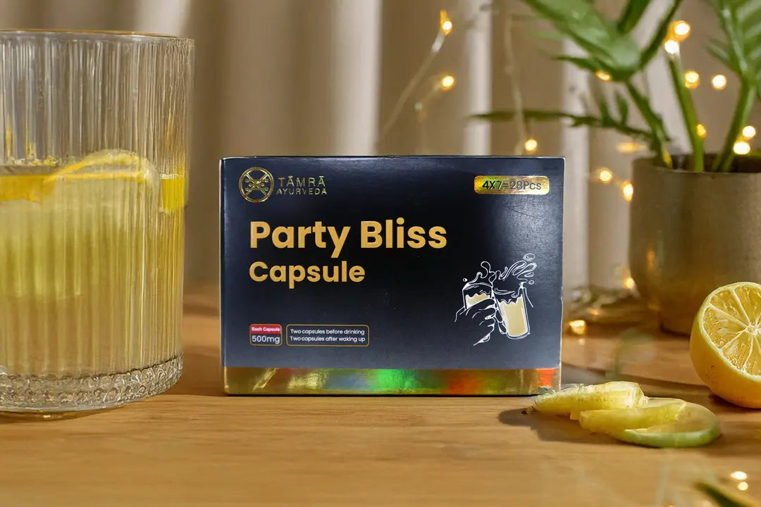 Box of 'Tamra Party Bliss Capsule' on a wooden surface with a glass of yellow liquid and lemon slices.
