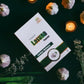 Tamra Lasuna Capsule packaging on a dark surface with garlic bulbs and candles.