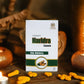 TAMRA Haridra Capsule packaging with capsules on a wooden surface with candles