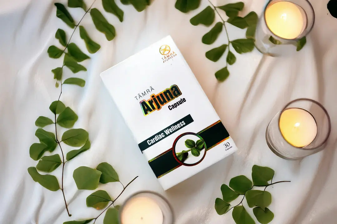 Box of Tampa Ajaina Capsule with green leaves and candles on a white surface