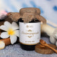 Jar of Tamra Chyawanprash with flowers and a spoon on a textured surface