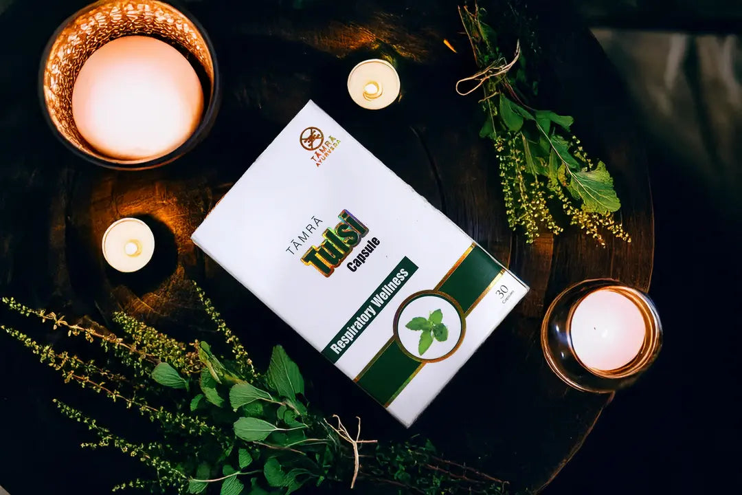 Candlelit scene with a box labeled 'Tamra Tulsi Capsule' on a dark surface.