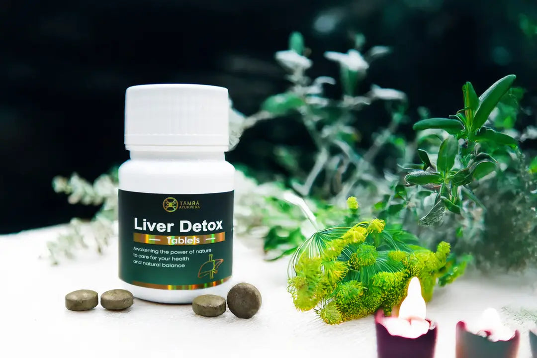 Tamra Ayurveda Liver Detox supplement bottle with tablets on a table with plants in the background