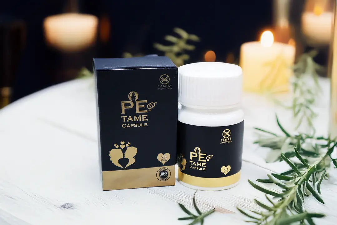 PE TAME capsule bottle and packaging on a table with candles and greenery in the background
