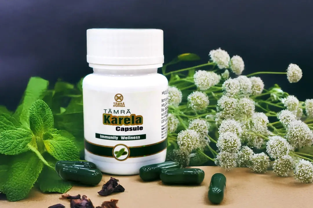 TAMRA Karela Capsule bottle with green capsules and herbs on a dark background