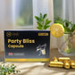 Box of Tamra Party Bliss Capsules with lemons and a glass of water on a table.