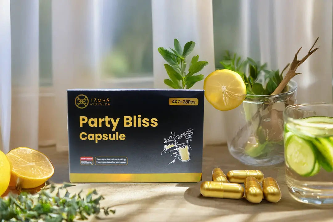 Box of Tamra Party Bliss Capsules with lemons and a glass of water on a table.