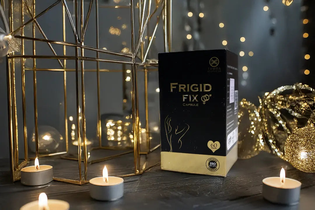 Tamra Ayurveda Frigid Fix product packaging with candles and decorative lanterns on a dark surface.