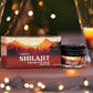 Tamra Ayurveda Shilajit packaging with candles and a blurred background of lights