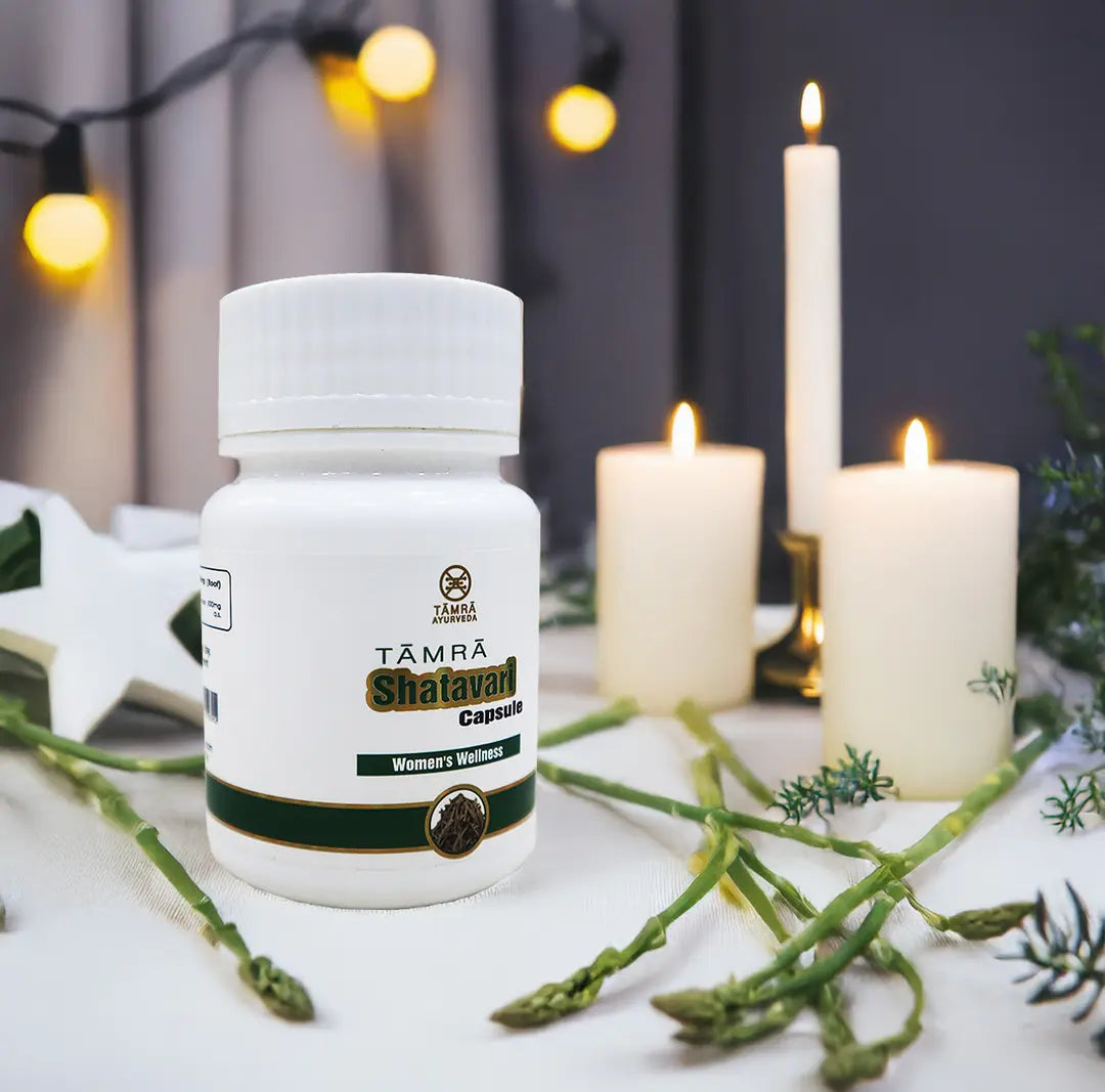 Tamra Shatavari capsule bottle with candles and green leaves on a decorative background