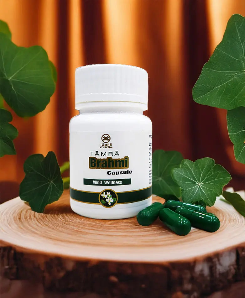 Tamra Brahmi capsule bottle on a wooden surface with green capsules. 