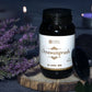 Jar of Chyawanprash with Tamra Ayurveda label on a wooden platform with purple flowers and candles in the background.
