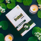 Box of Tamra Brahmi Capsules with candles and leaves on a dark background