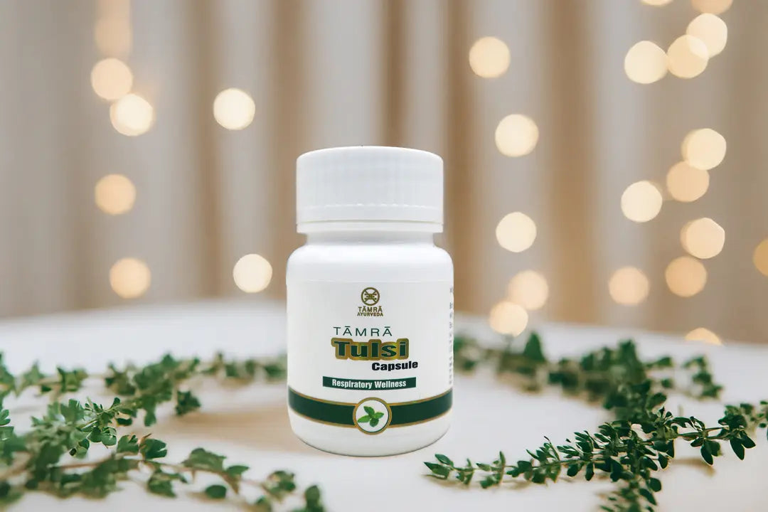 White bottle labeled 'Tamra Tulsi' with green leaves on a blurred background
