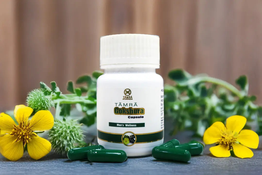 White bottle labeled 'Yamra Goldaura Capsule' with green capsules on a wooden surface with yellow flowers and green leaves.