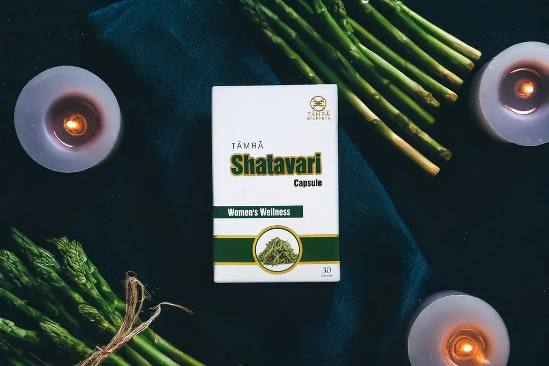 Tamra Shatavari capsule box with green leaves and candles on a dark background