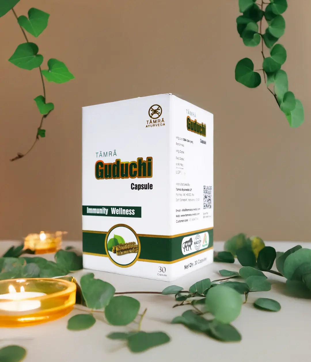 Box of Tamra Guduchi Capsules with green leaves and a candle in the background