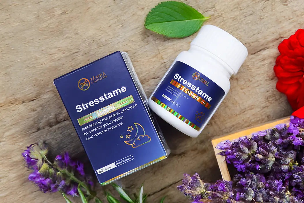 Tamra Ayurveda Stresstame supplement bottle and packaging on a wooden surface.