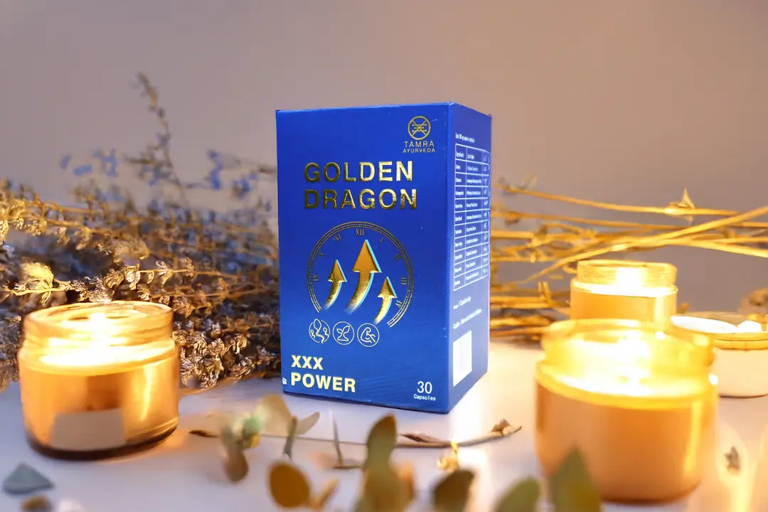 Tamra Ayurveda 'Golden Dragon Capsules' with lit candles and decorative plants on a neutral background.