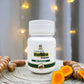 White bottle of Tamra Haridra Capsule with turmeric slices on a wooden surface.