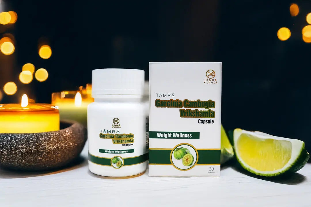 Tamra Garcinia Cambogia Weight Wellness supplement bottle and packaging on a table with candles and lime slices in the background.