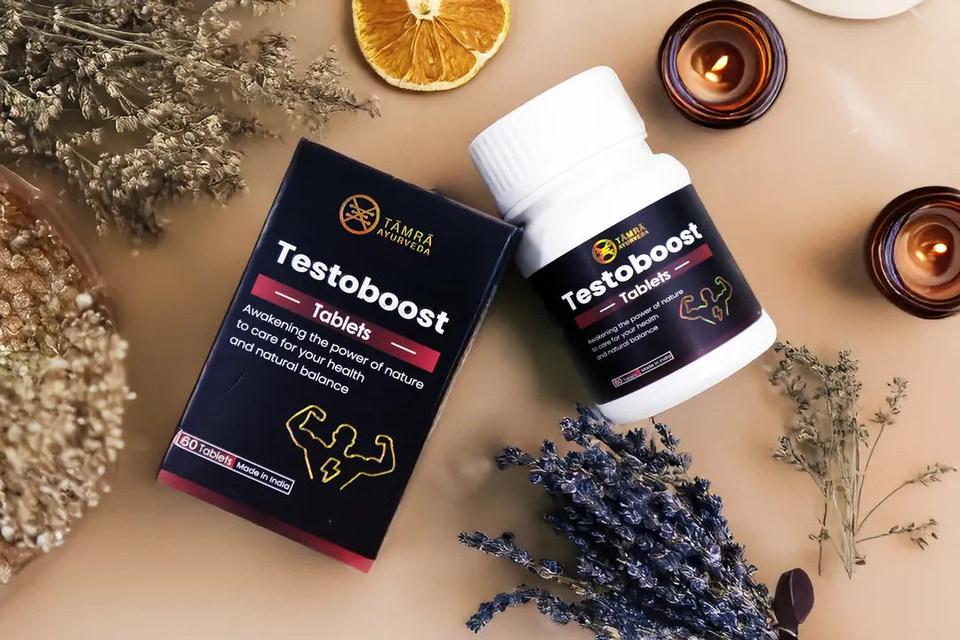 Tamra Testoboost supplement bottle and packaging on a textured surface with dried plants and candles.