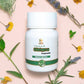 TAMRA Ayurveda Shigru Capsule bottle on a pink background with herbs and flowers