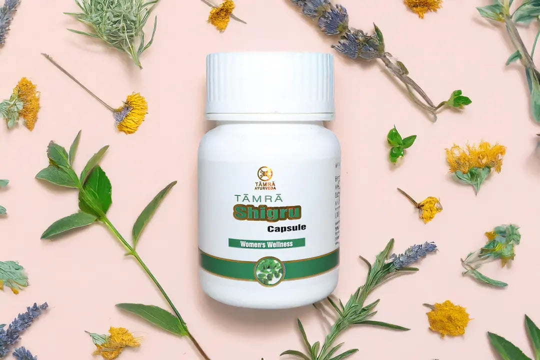 TAMRA Ayurveda Shigru Capsule bottle on a pink background with herbs and flowers